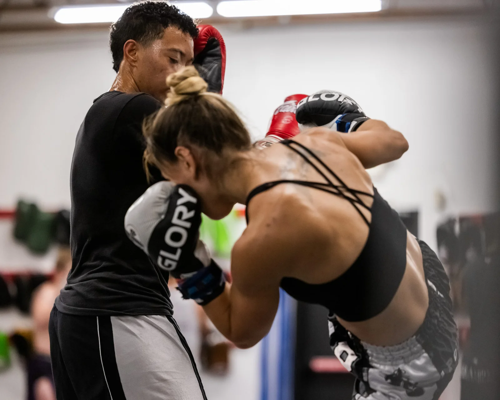 A Kid and a Woman Muay Thai partner drills at Pound 4 Pound in Littleton, Colorado