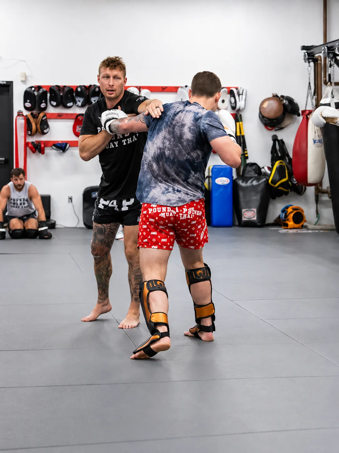 Muay Thai coach working on striking technique with an adult student at Pound 4 Pound in Littleton, Colorado