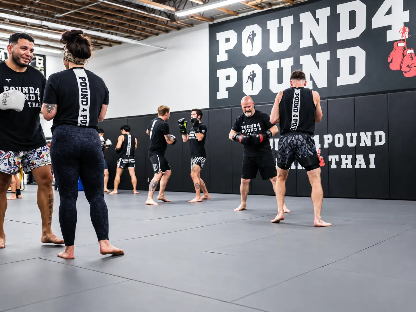 Pound 4 Pound student practicing a Muay Thai knee strike during partner training in Littleton
