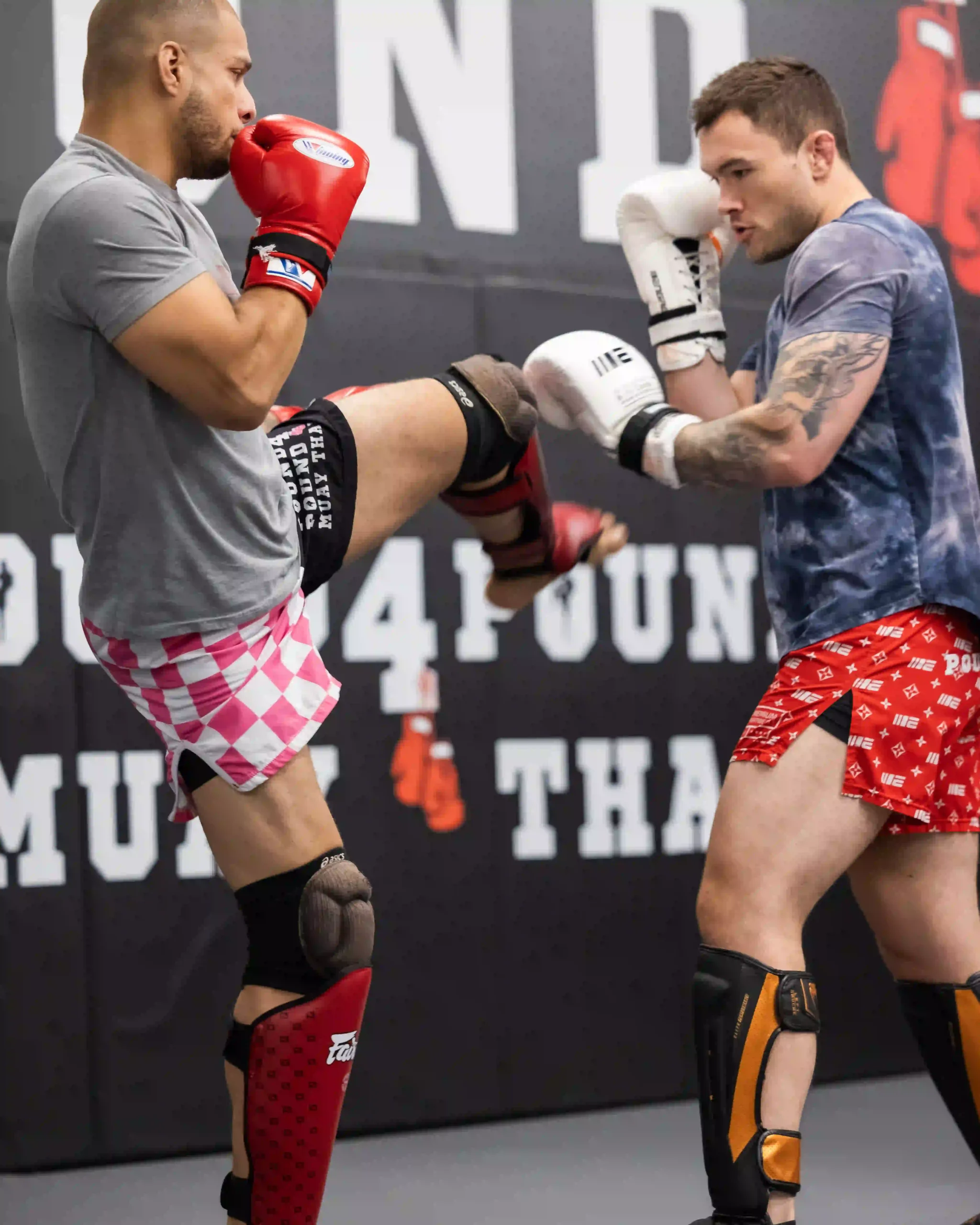 Pound 4 Pound student practicing a Muay Thai knee strike during partner training in Littleton