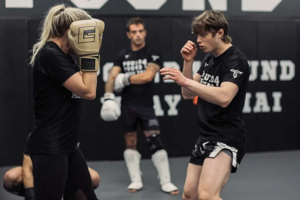 Two students practicing Muay Thai partner drills at Pound 4 Pound Muay Thai in Littleton, Colorado