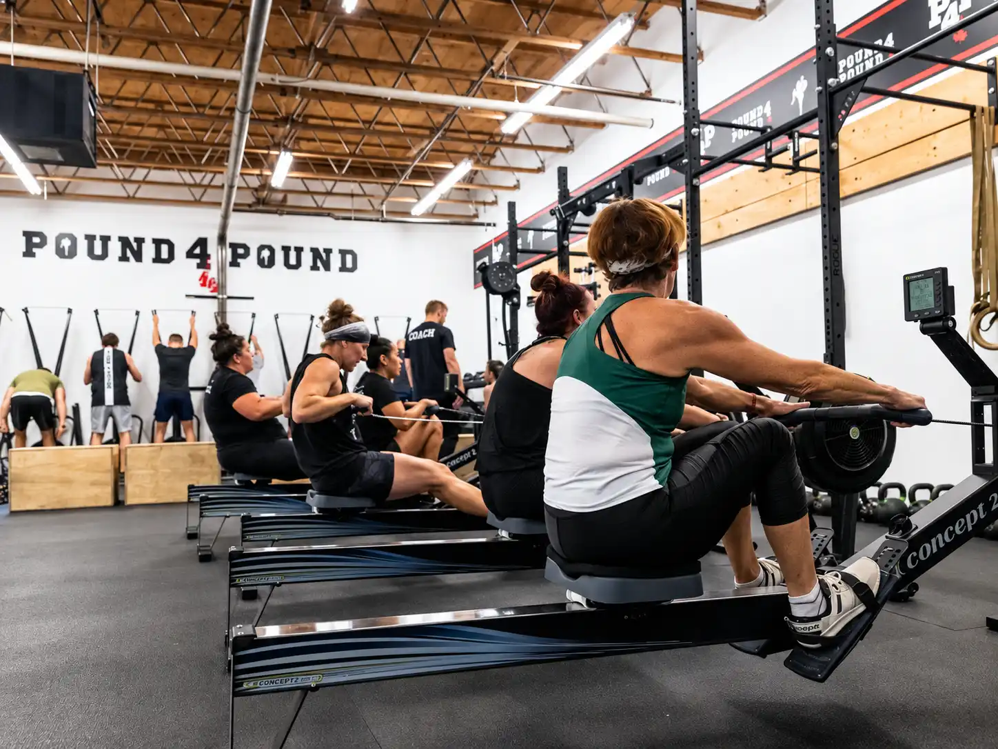 Members training on rowing machines during a strength and conditioning class at Pound 4 Pound in Littleton, Colorado