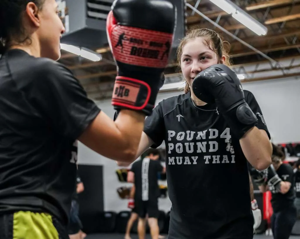 Youth Muay Thai student practicing punching drills with a training partner at Pound 4 Pound in Littleton